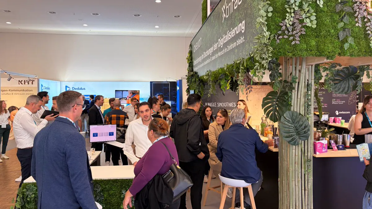 Gut besuchter Stand von axelion an der IFAS 2026 mit Pflanzenwand, Bambus und Bar